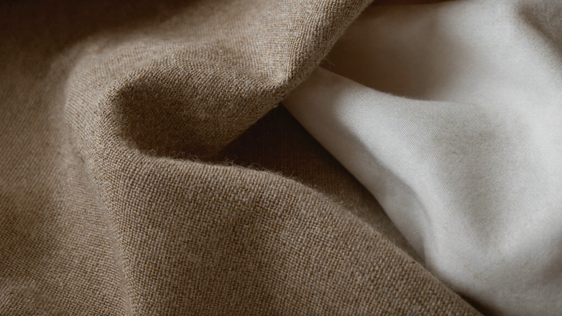 Close-up of slub-textured linen fabric beside smooth cotton — linen vs cotton comparison