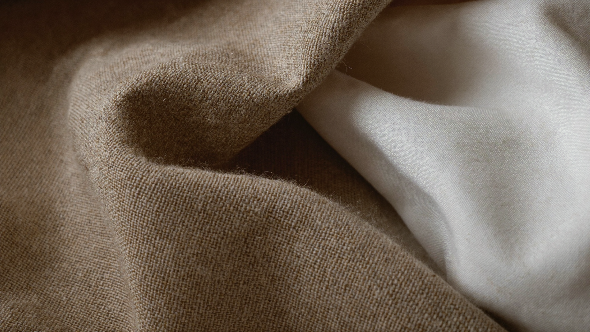 Close-up of slub-textured linen fabric beside smooth cotton — linen vs cotton comparison