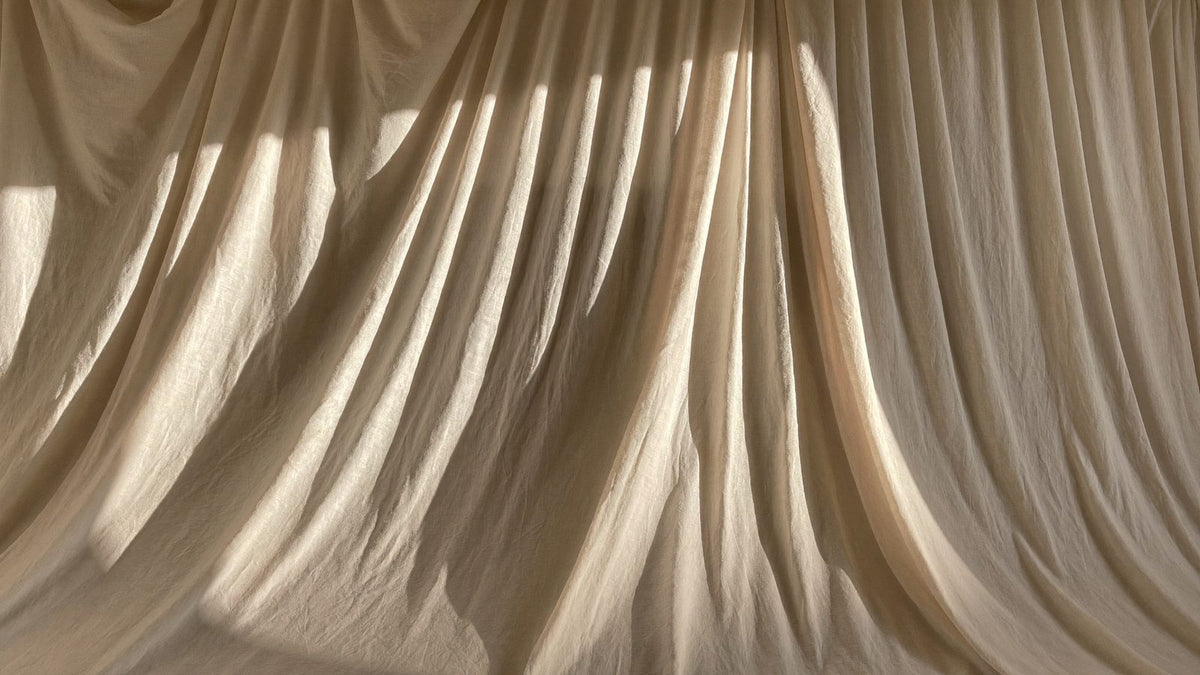 Draped natural cream linen in warm light