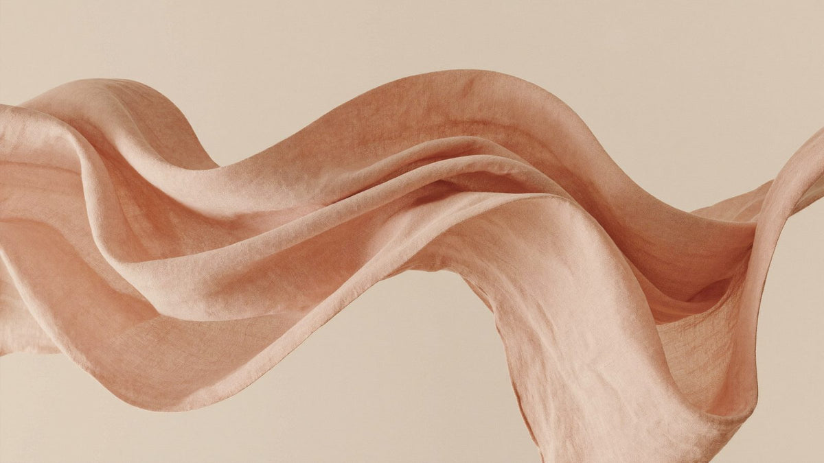 Blush linen fabric flowing mid-air like a wave